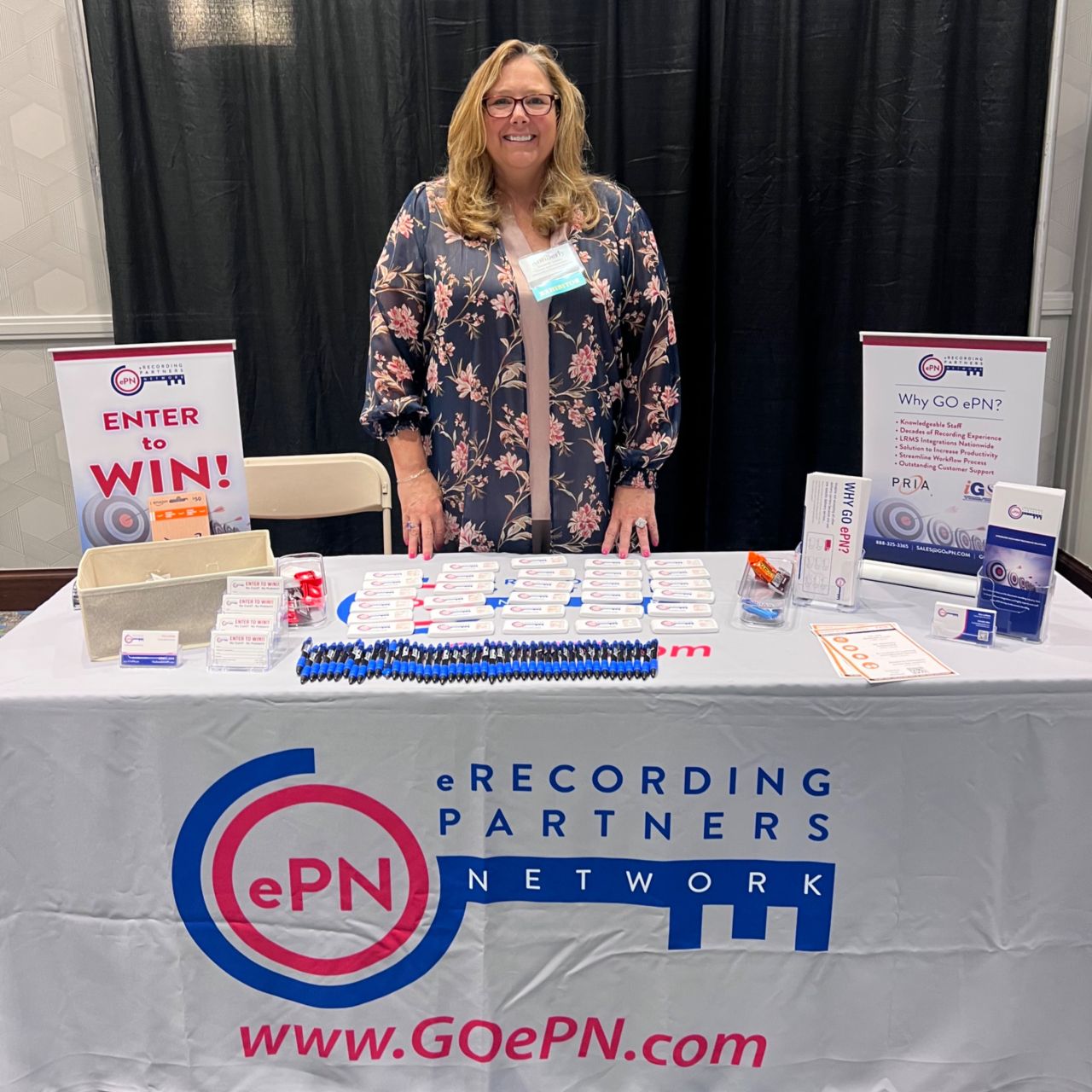 picture of person behind table at conference 